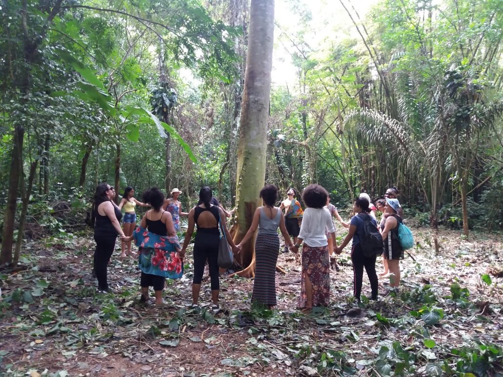 Pessoa interagindo com a natureza e as árvores na aldeia